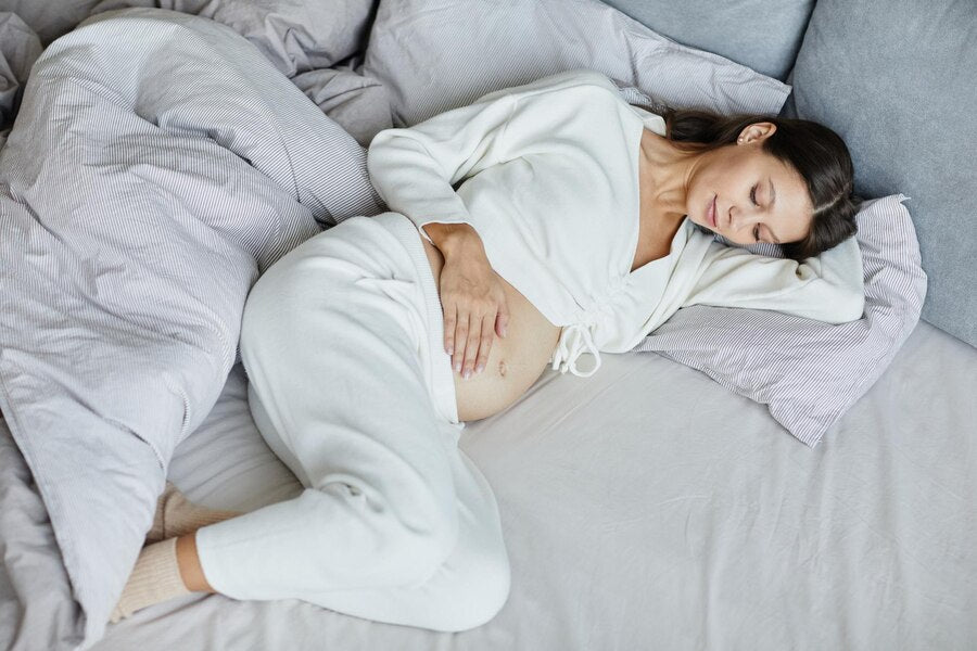 pregnant woman sleeping on her bed